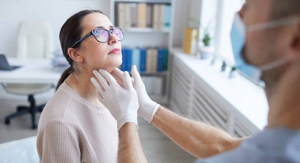 istockphoto-1296415671-612x612 Close up of unrecognizable male doctor palpating throat of woman while examining female patient during consultation in clinic